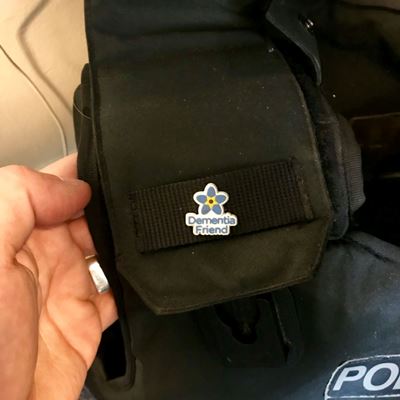 Image of police officer's uniform with Dementia Friends badge attached